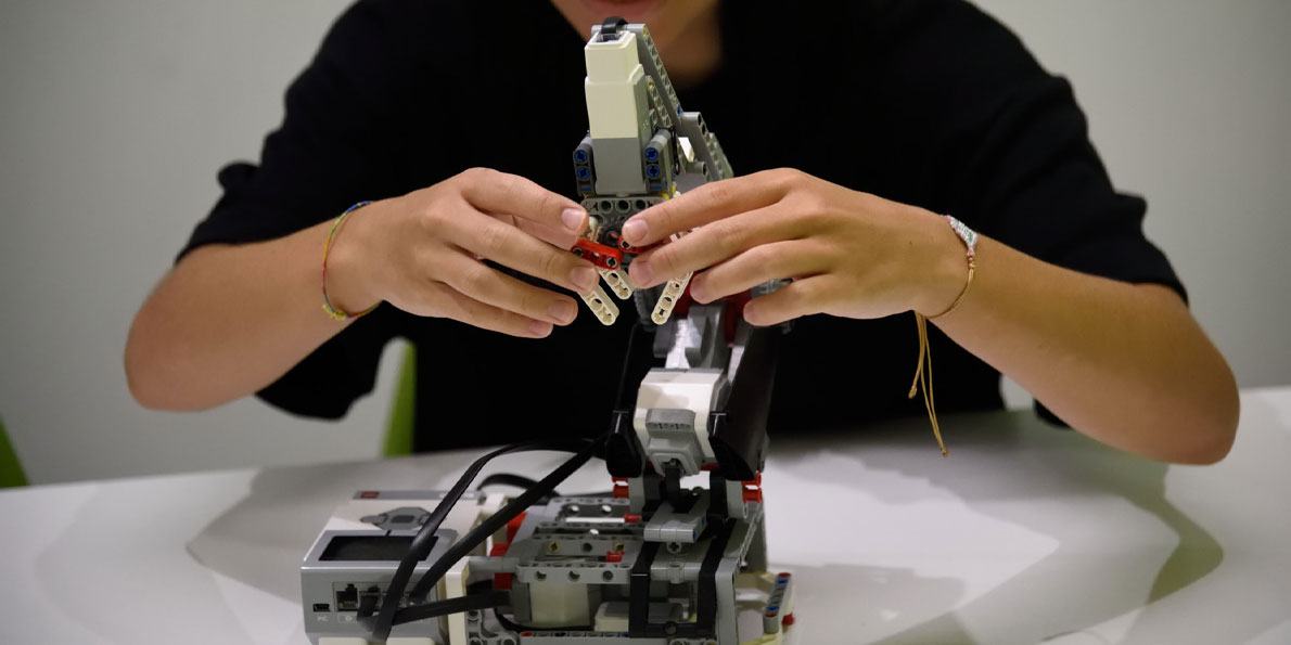 Χαρούμενο κορίτσι επεξεργάζεται ρομποτική κατασκευή