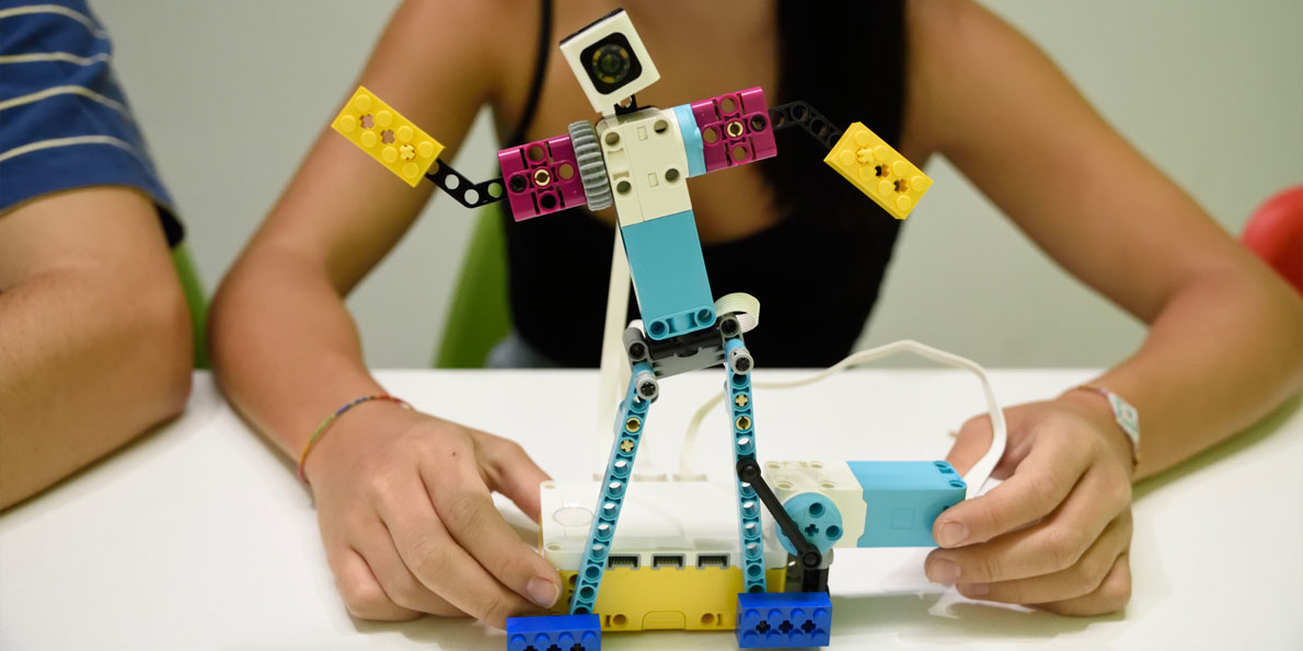 Κορίτσι κρατάει την κατασκευή χορευτής από το εκπαιδευτικό πακέτο Spike Prime