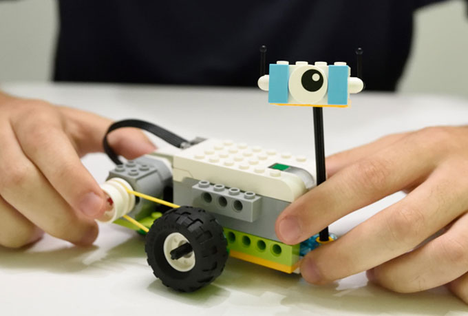 Χέρια παιδιού που κρατάνε την κατασκευή Milo από το εκπαιδευτικό πακέτο WeDo 2.0