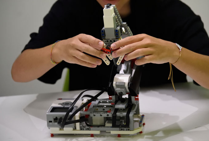 Χαρούμενο κορίτσι επεξεργάζεται ρομποτική κατασκευή