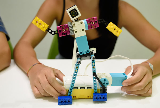 Κορίτσι κρατάει την κατασκευή χορευτής από το εκπαιδευτικό πακέτο Spike Prime